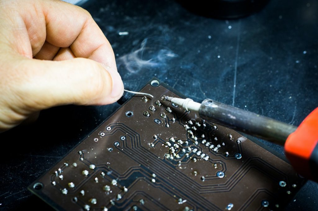 A person soldering a board.